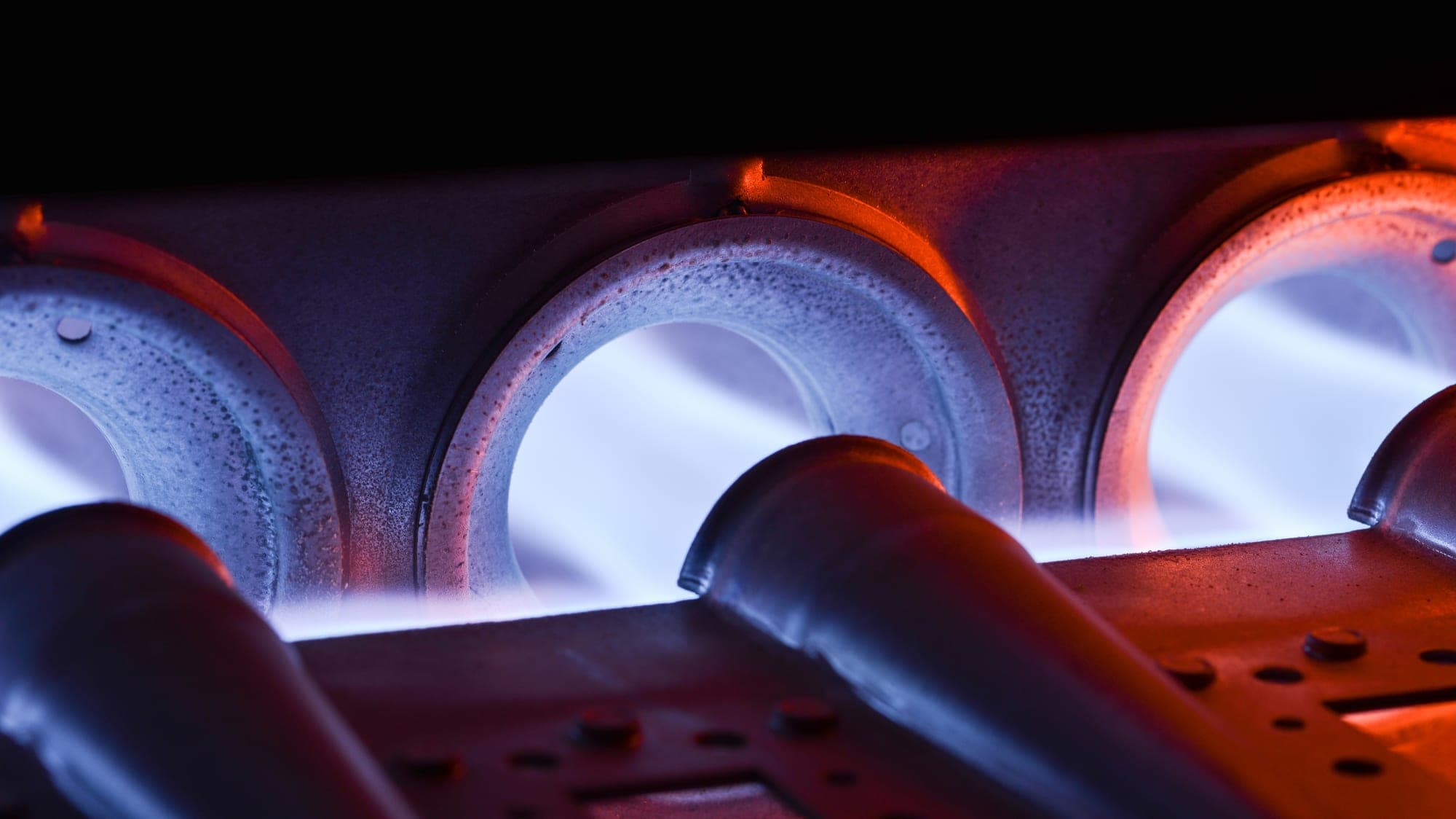 Gas furnace burners showing blue flames