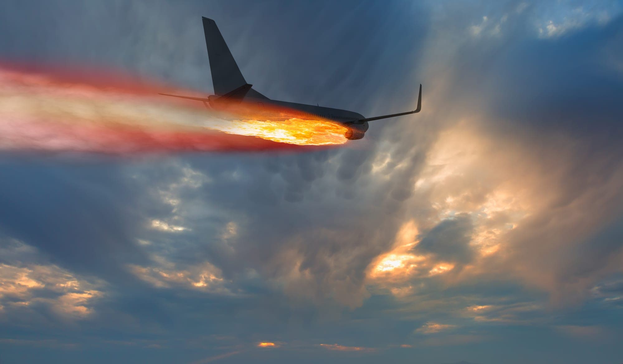 Airliner in flight trailing flames and smoke from its engine