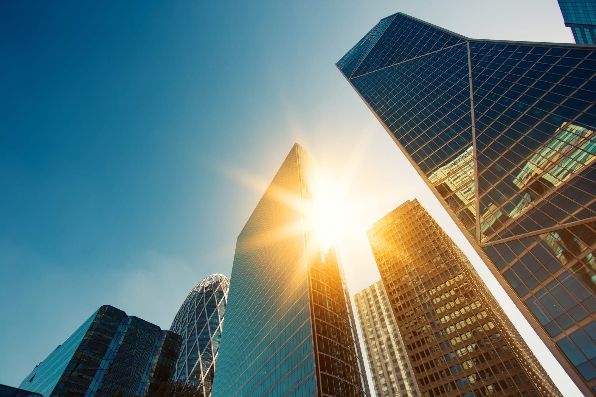 Glass high-rise office towers against a sunlit sky