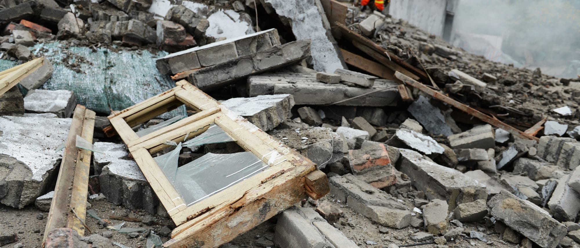 Damaged house with upper floor collapsed onto the level below