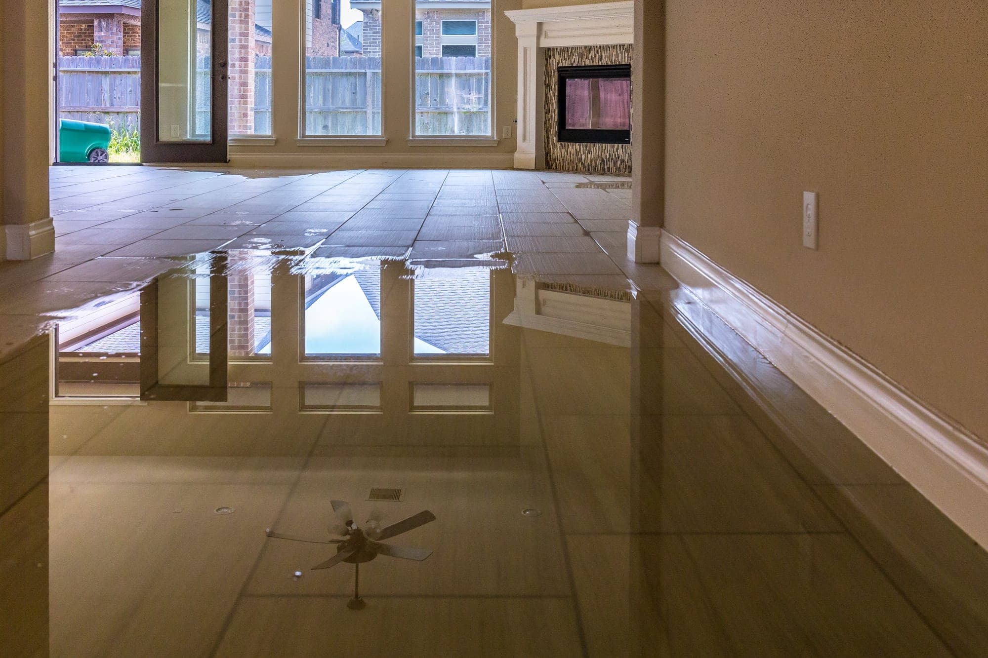 Standing water pooled on the tile floor inside a home