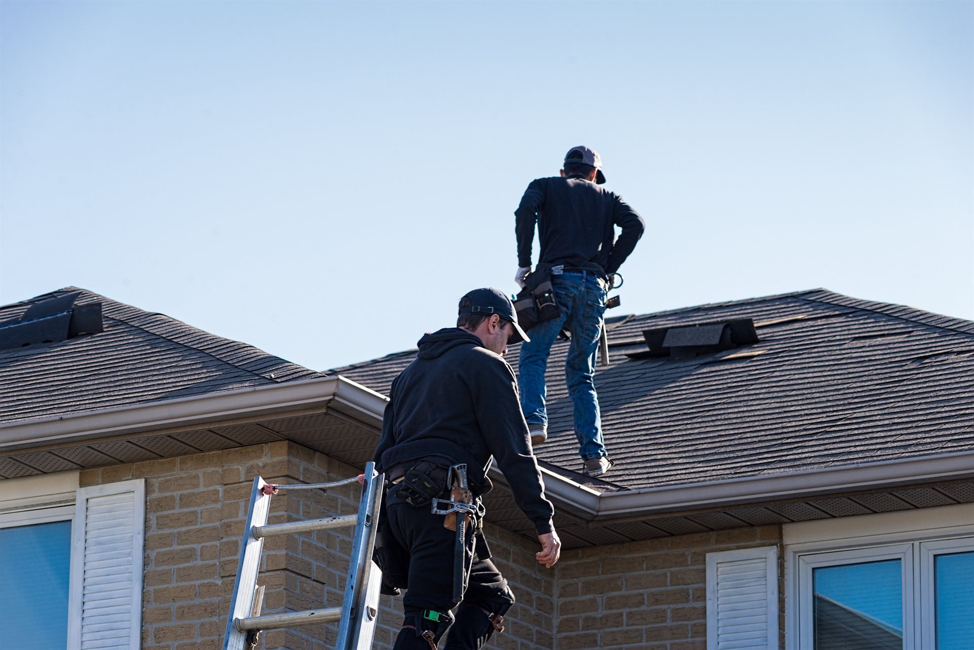 Close inspection of damaged asphalt shingles on a residential roof